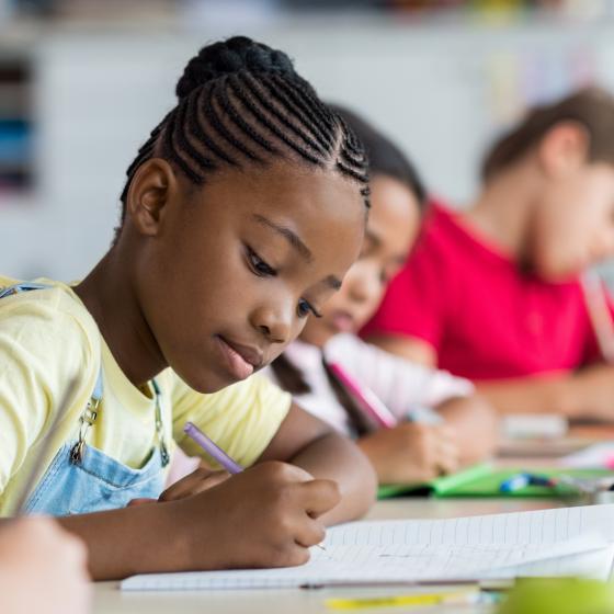 girl writing at school desk